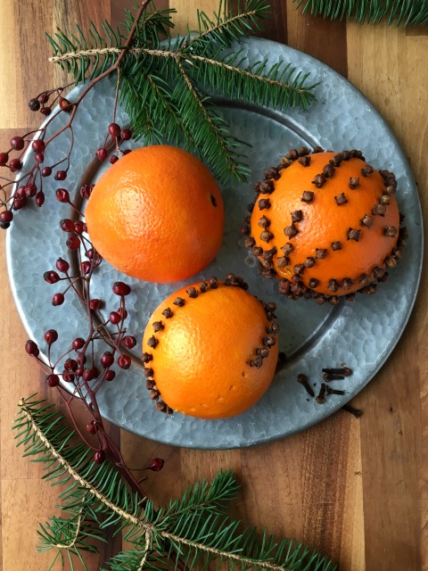 How to make pomanders: oranges studded with whole cloves. 